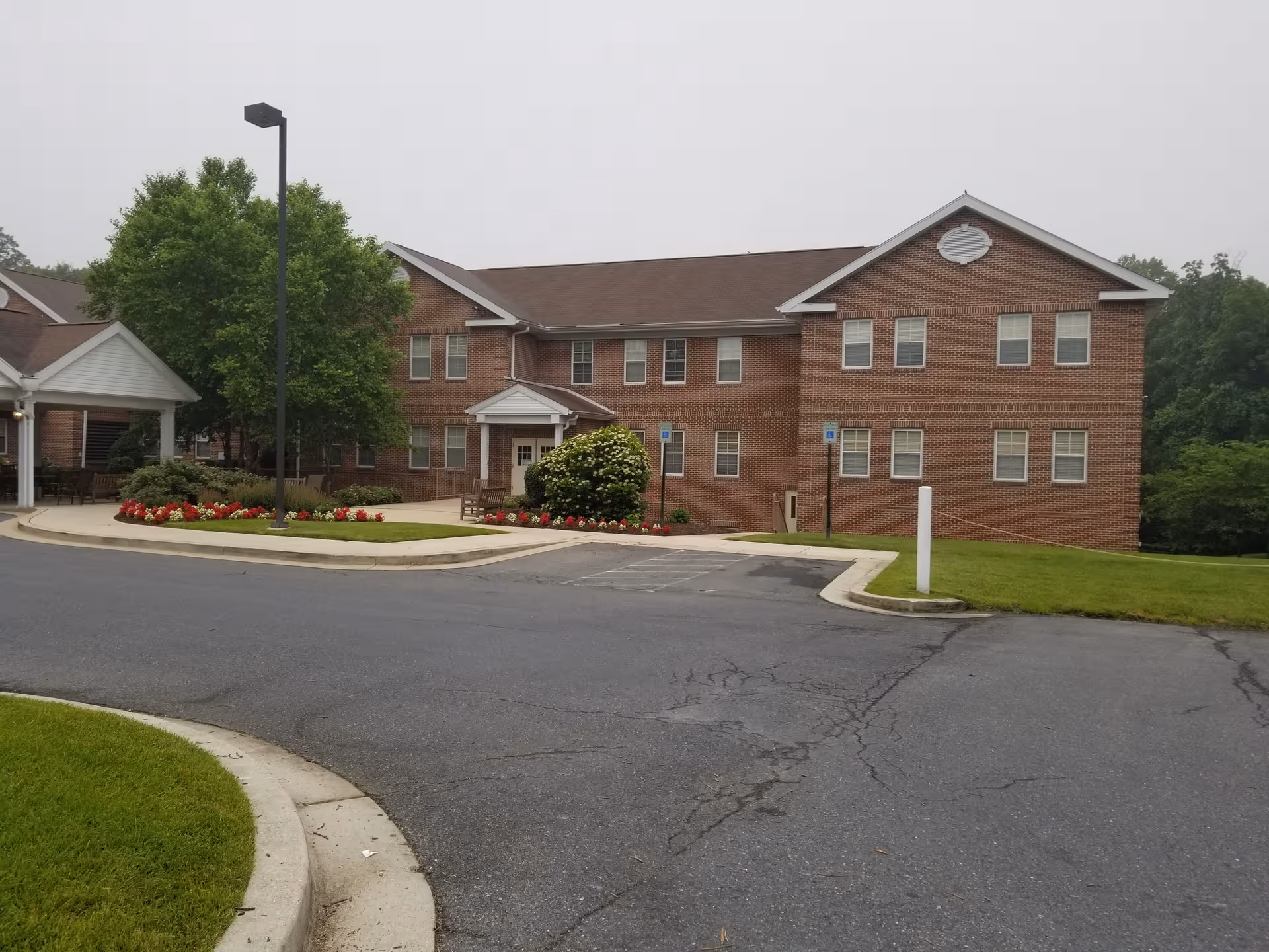 Exterior view of Sterling Care Hillhaven building with parking lot and landscaping.