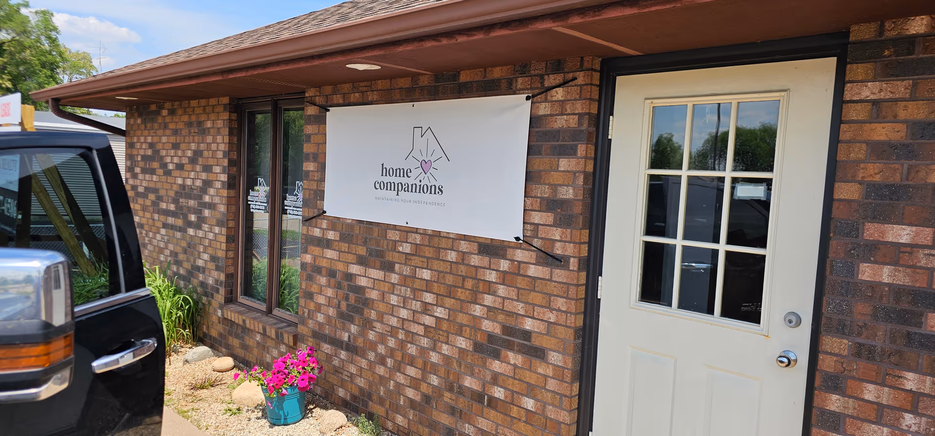 Brick exterior with a white door and Home Companions banner.