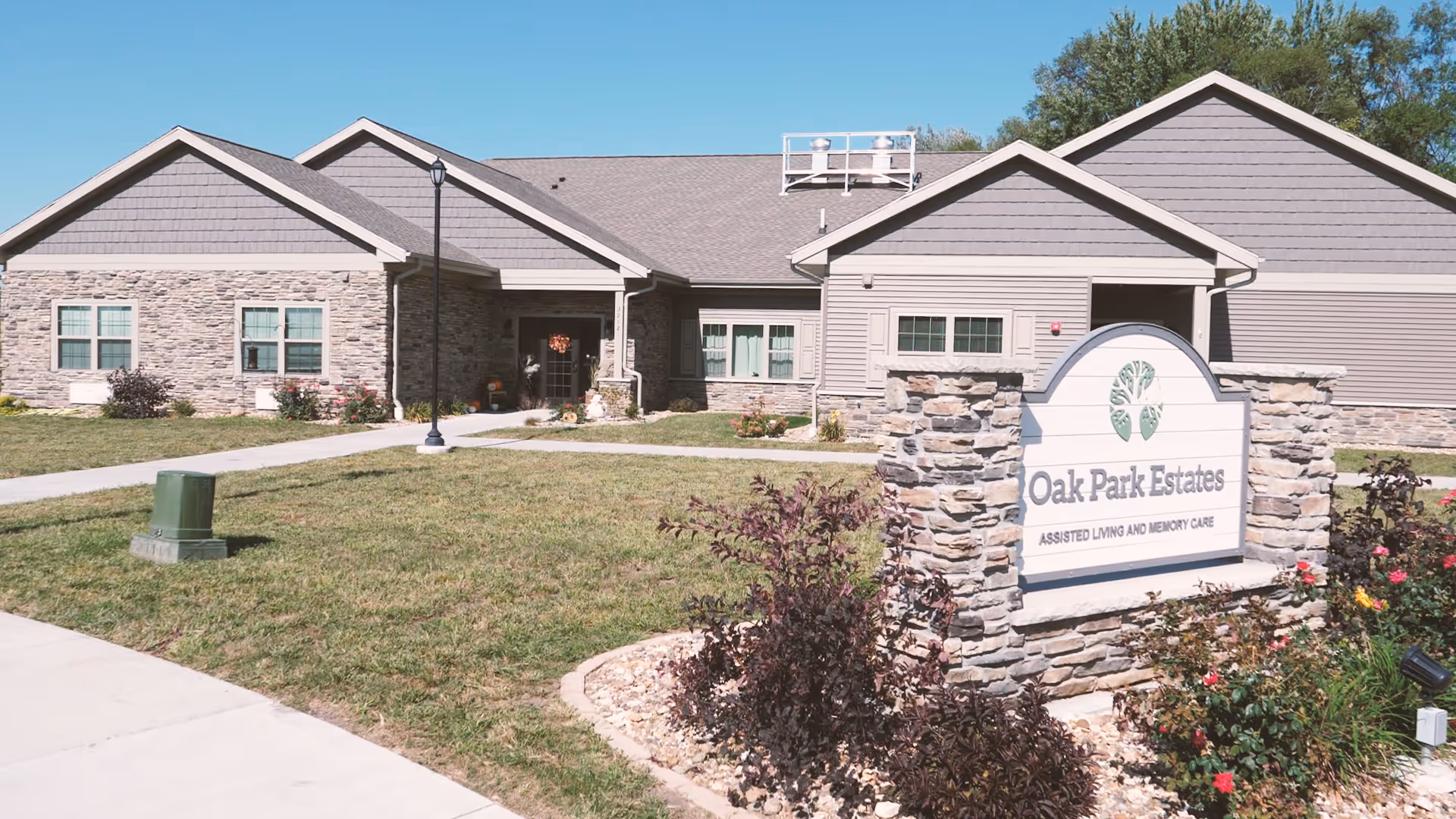 Front view of Oak Park Estates Assisted Living building with stone sign and landscaping.