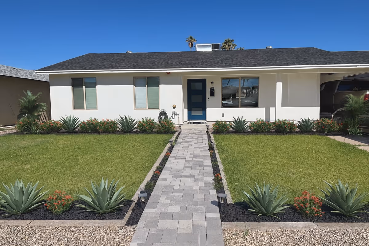 Front exterior of a single-story Aspire Care Home facility with walkway and landscaped yard.