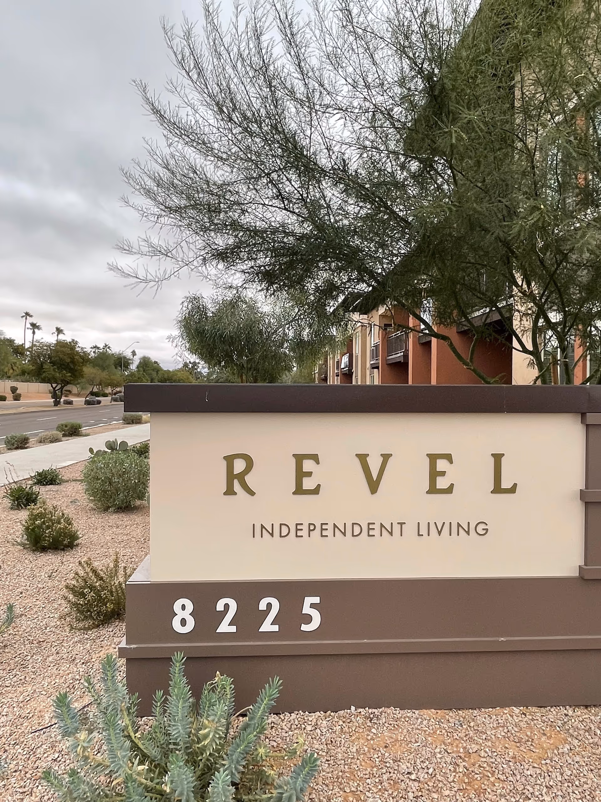 Exterior Revel Scottsdale sign with landscaping and building facade in the background.