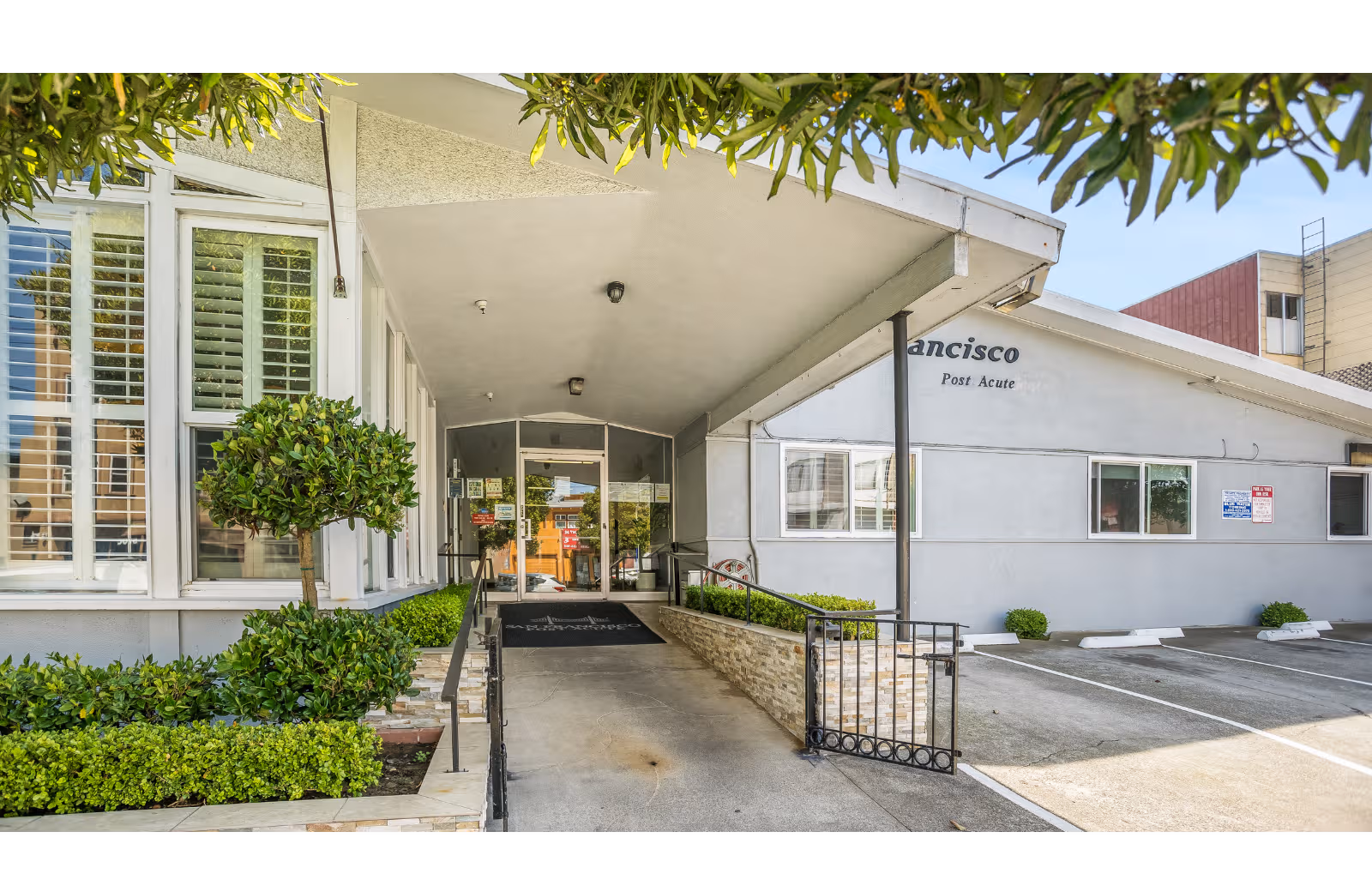 Exterior entrance to San Francisco Post Acute with awning and landscaped walkway.