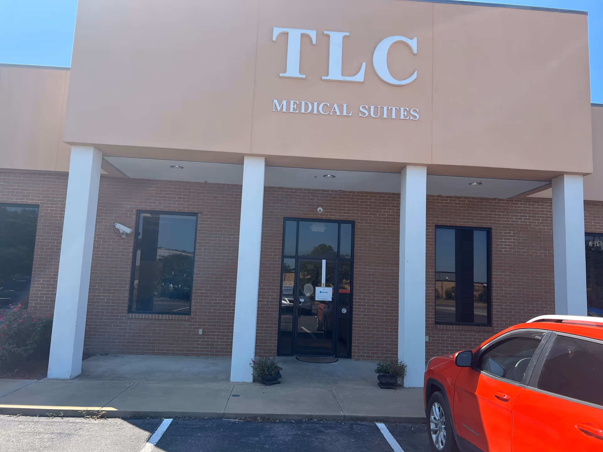Front view of TLC Medical Suites entrance with brick exterior and white columns.
