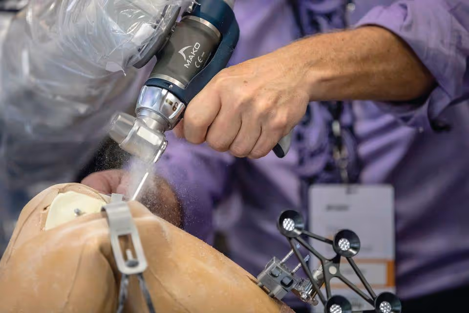 Close-up of a surgeon using a robotic-assisted instrument during orthopedic surgery.