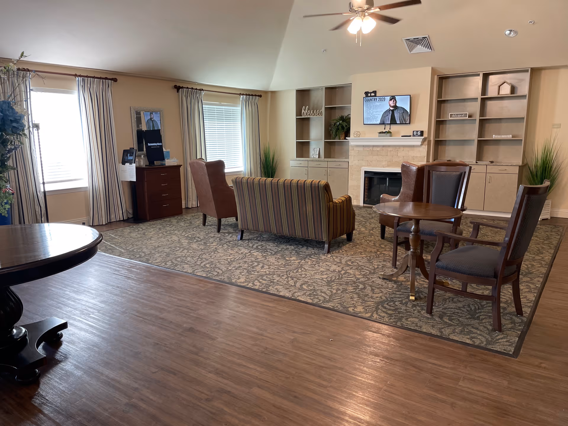 Spacious lounge with striped sofa, chairs, fireplace, and built-in shelves.