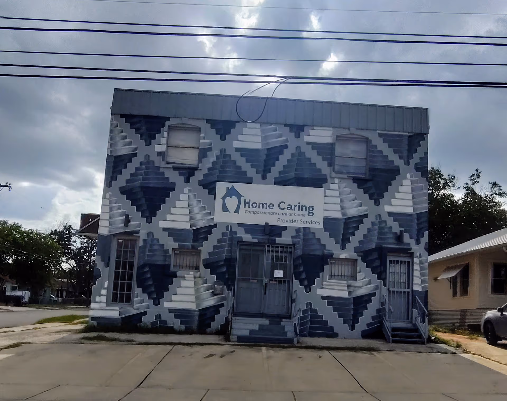 Exterior of Home Caring facility with geometric blue wall and front entrance.