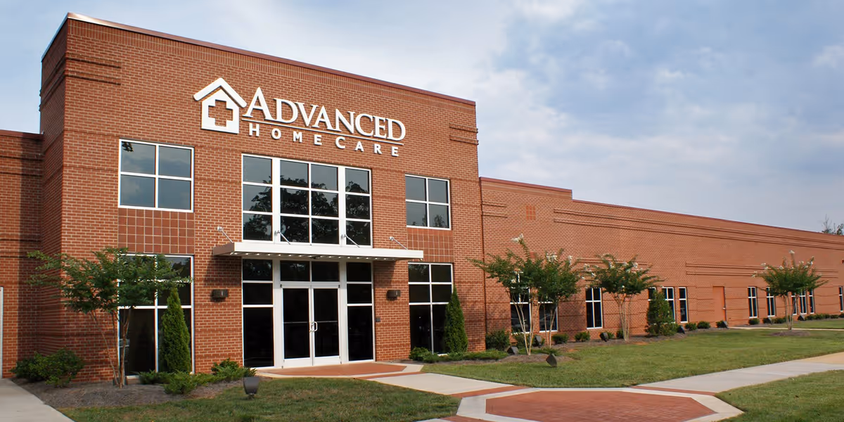 Brick facility with glass entrance and Advanced Home Care sign on the front.