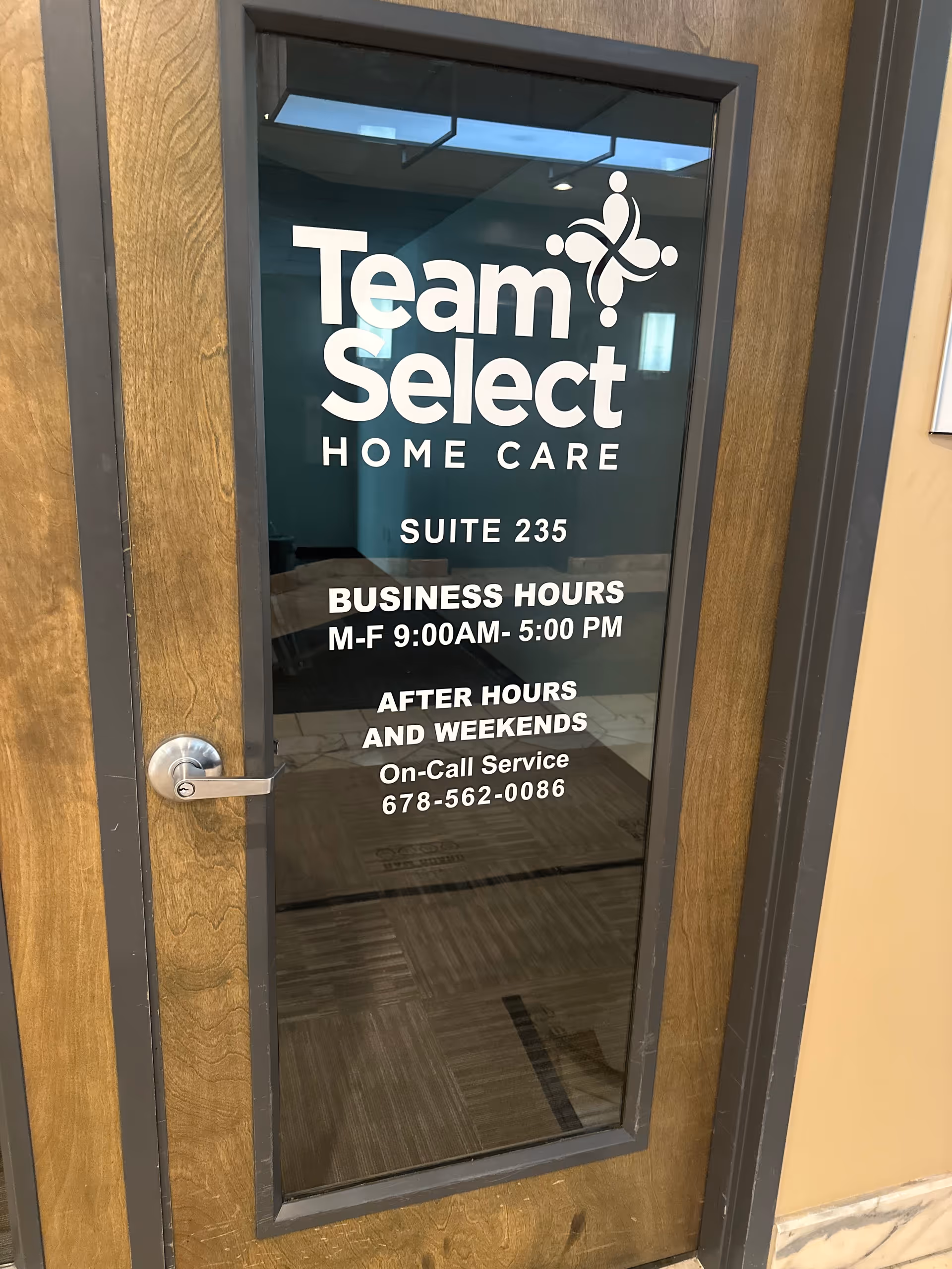A glass door displays the Team Select Home Care logo and business hours.
