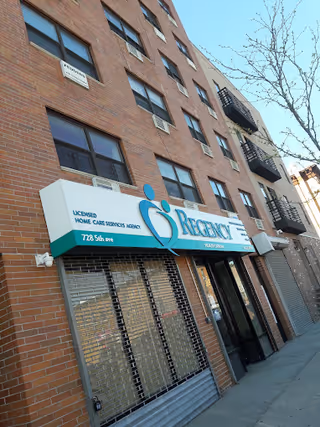 Brick building with Regency Health Care storefront sign and closed metal security gates.