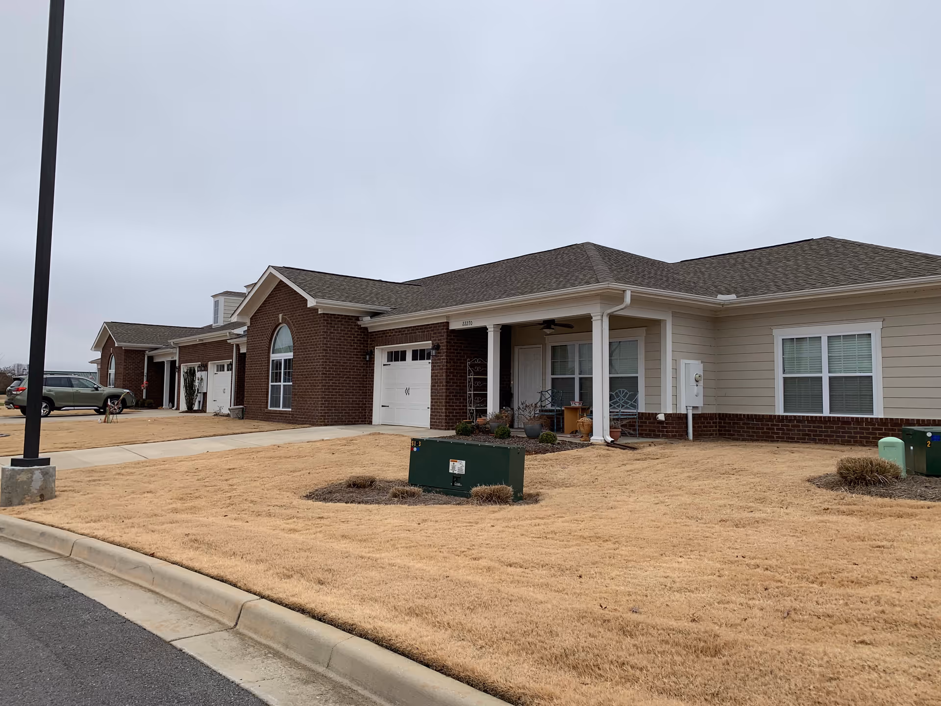 Single-story senior living facility exterior with brick facade and covered entrance.