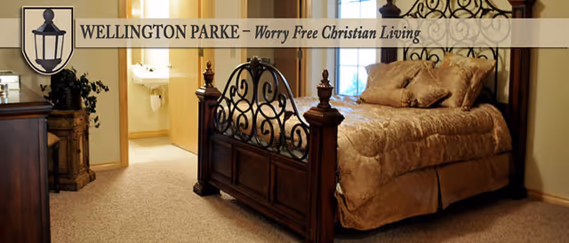Bedroom with an ornate iron-bed frame, beige bedding, and a decorative header banner.