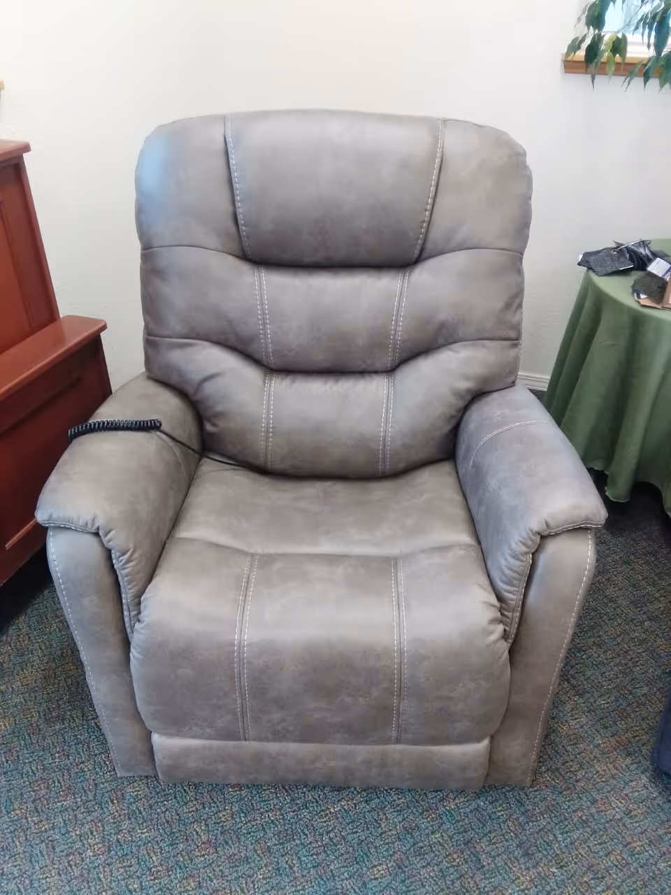 Gray reclining armchair in a furnished senior living facility lounge
