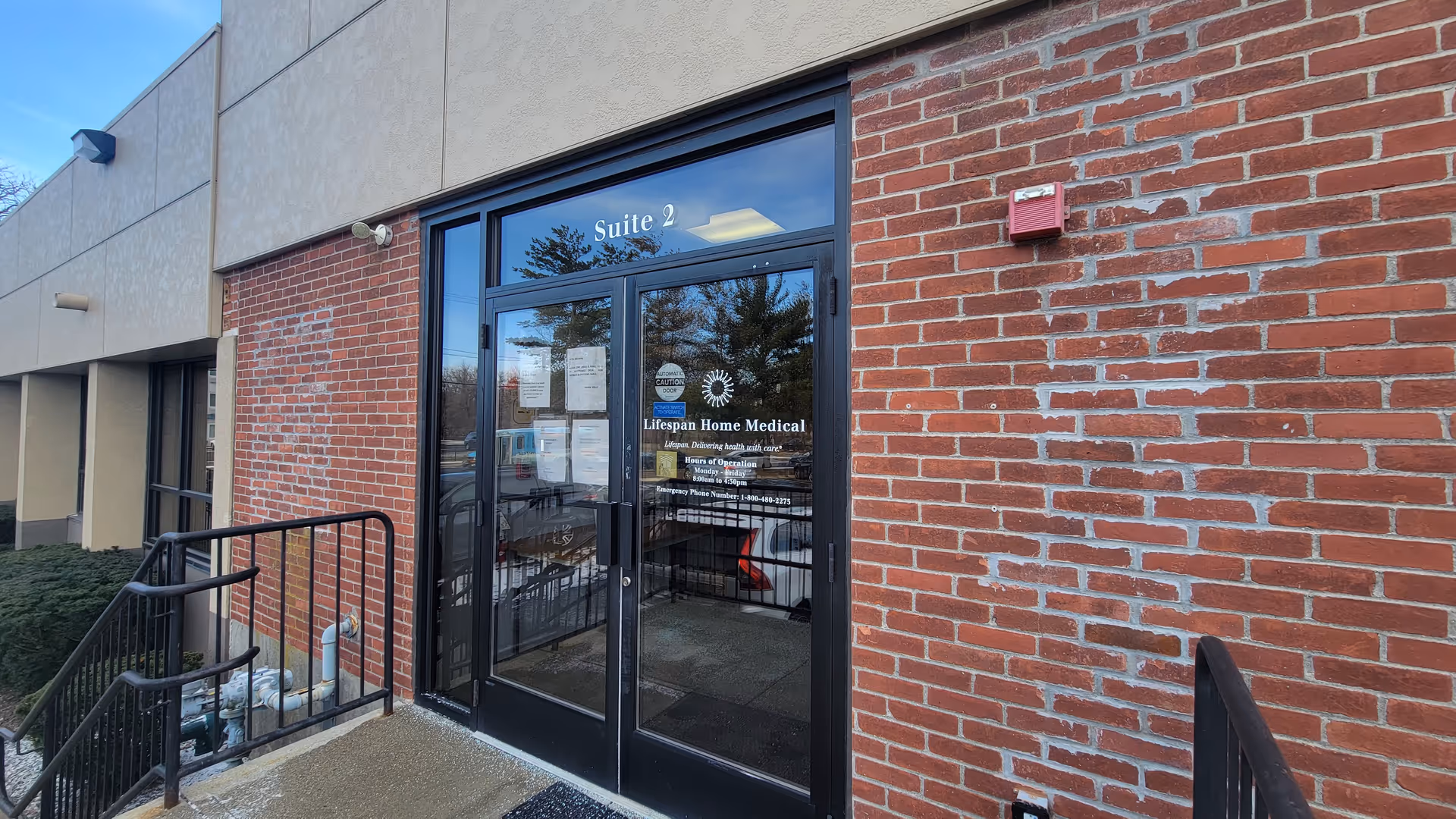 Brick exterior entrance of a medical facility with glass doors labeled 'Suite 2'.