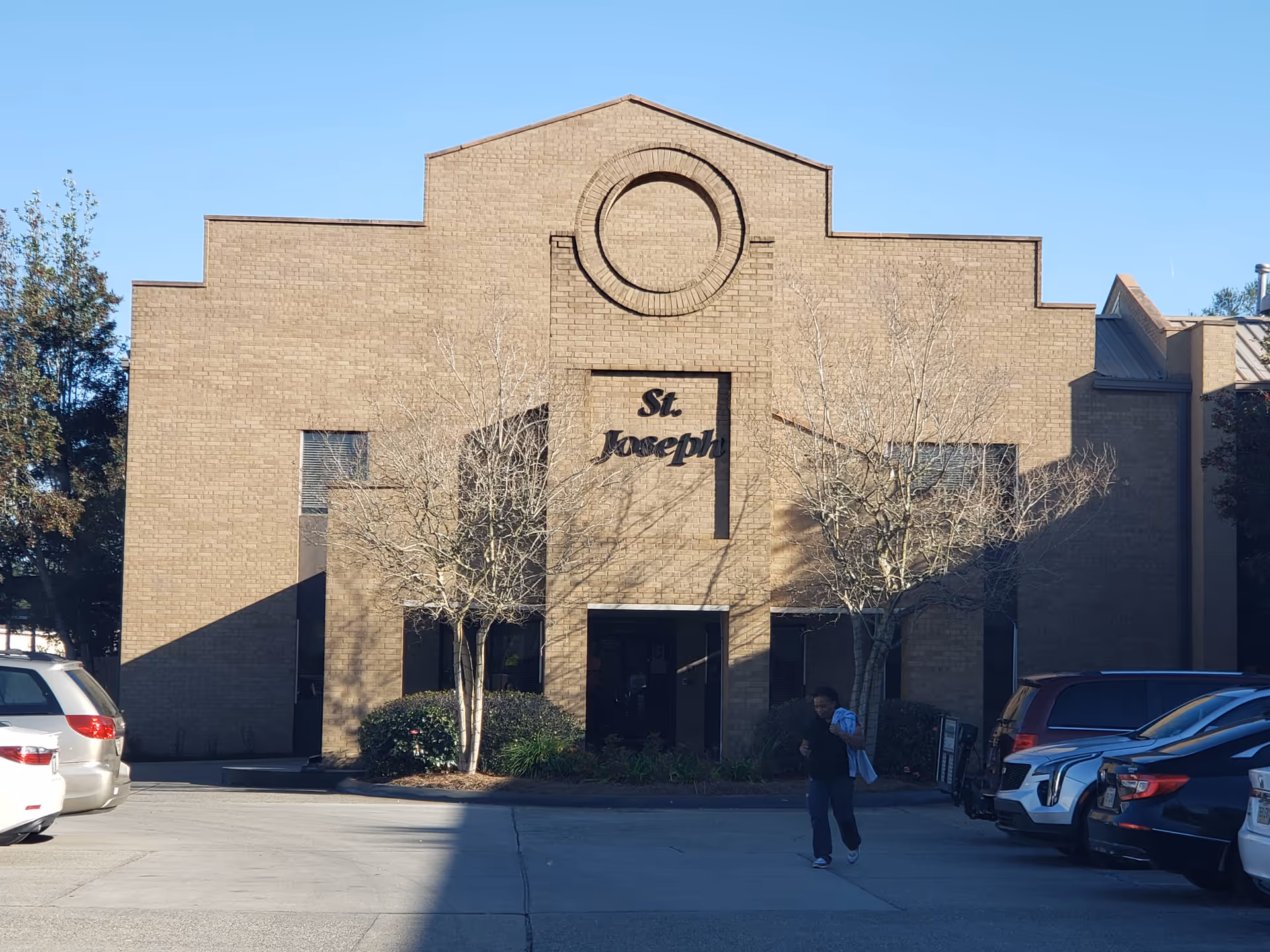 Exterior brick nursing home with a circular emblem and St. Joseph sign.
