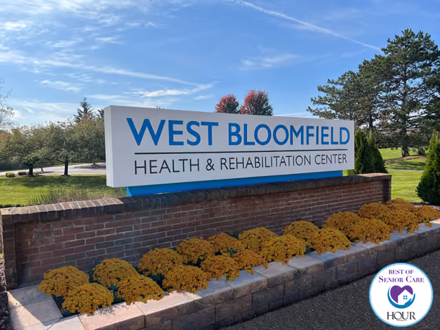 West Bloomfield Health and Rehabilitation Center sign on brick wall with flowers.