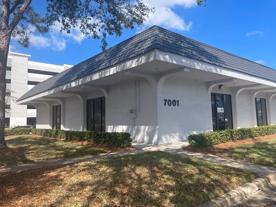 Exterior view of a white building with a sloped roof and 7001.
