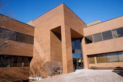 Brick exterior of Mercy Home Health facility with glass entrance and clear blue sky