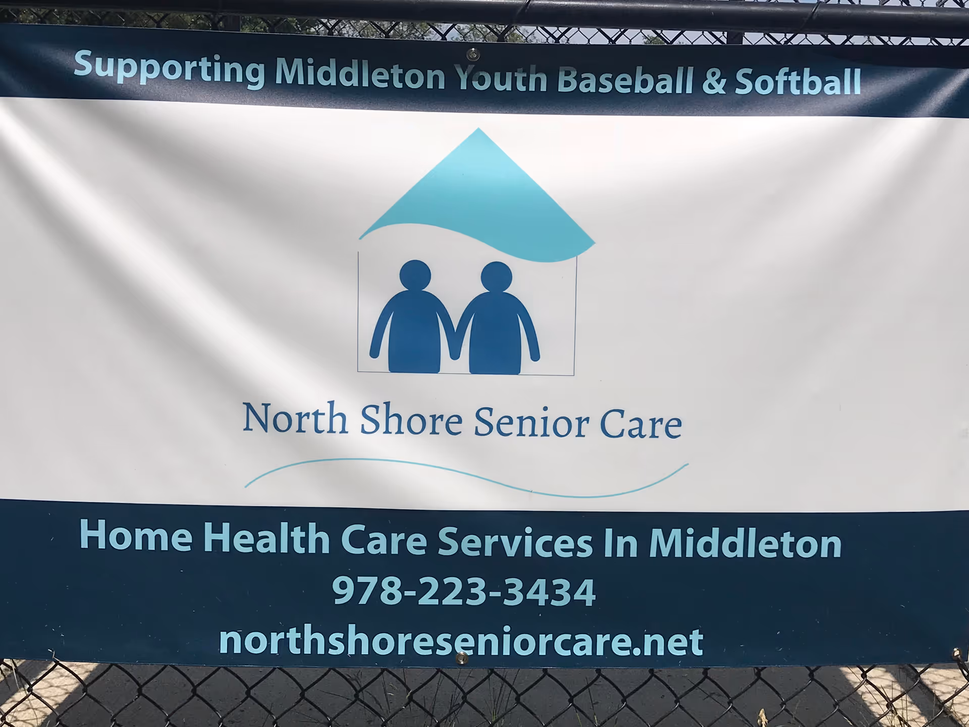 Large exterior sign for North Shore Senior Care LLC with contact details and banner