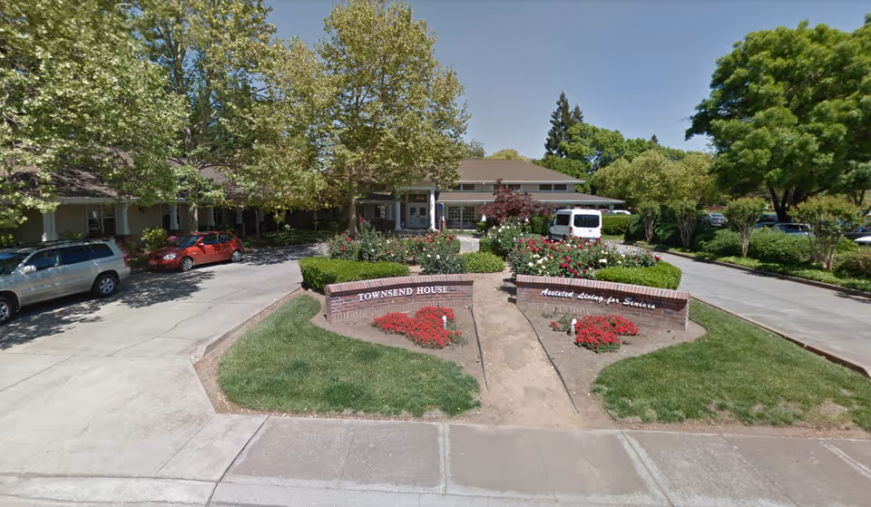 Exterior view of Townsend House senior living facility with landscaped entrance and parking.