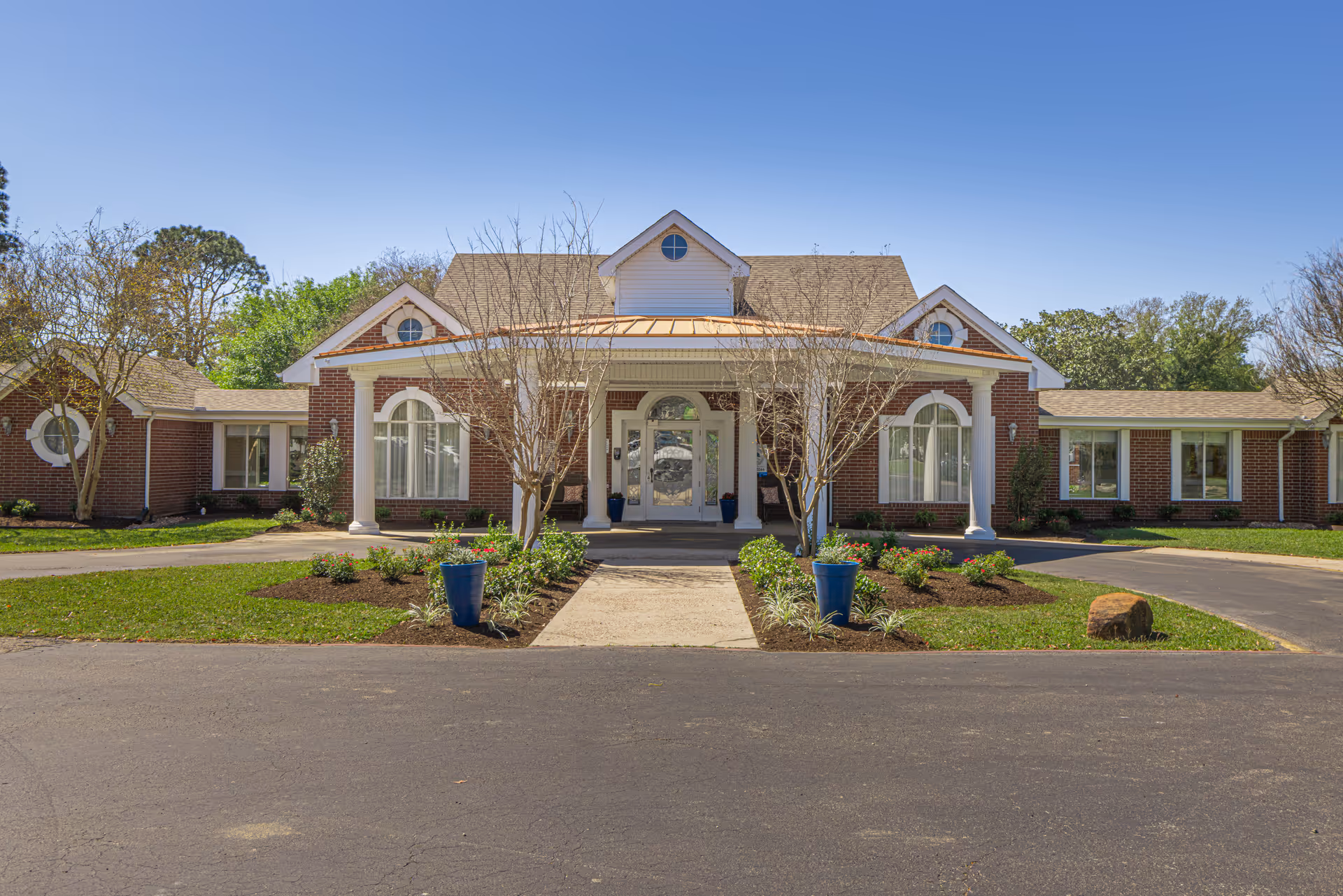 Exterior view of Magnolia Manor's brick facility with a welcoming front entrance and landscaped grounds.