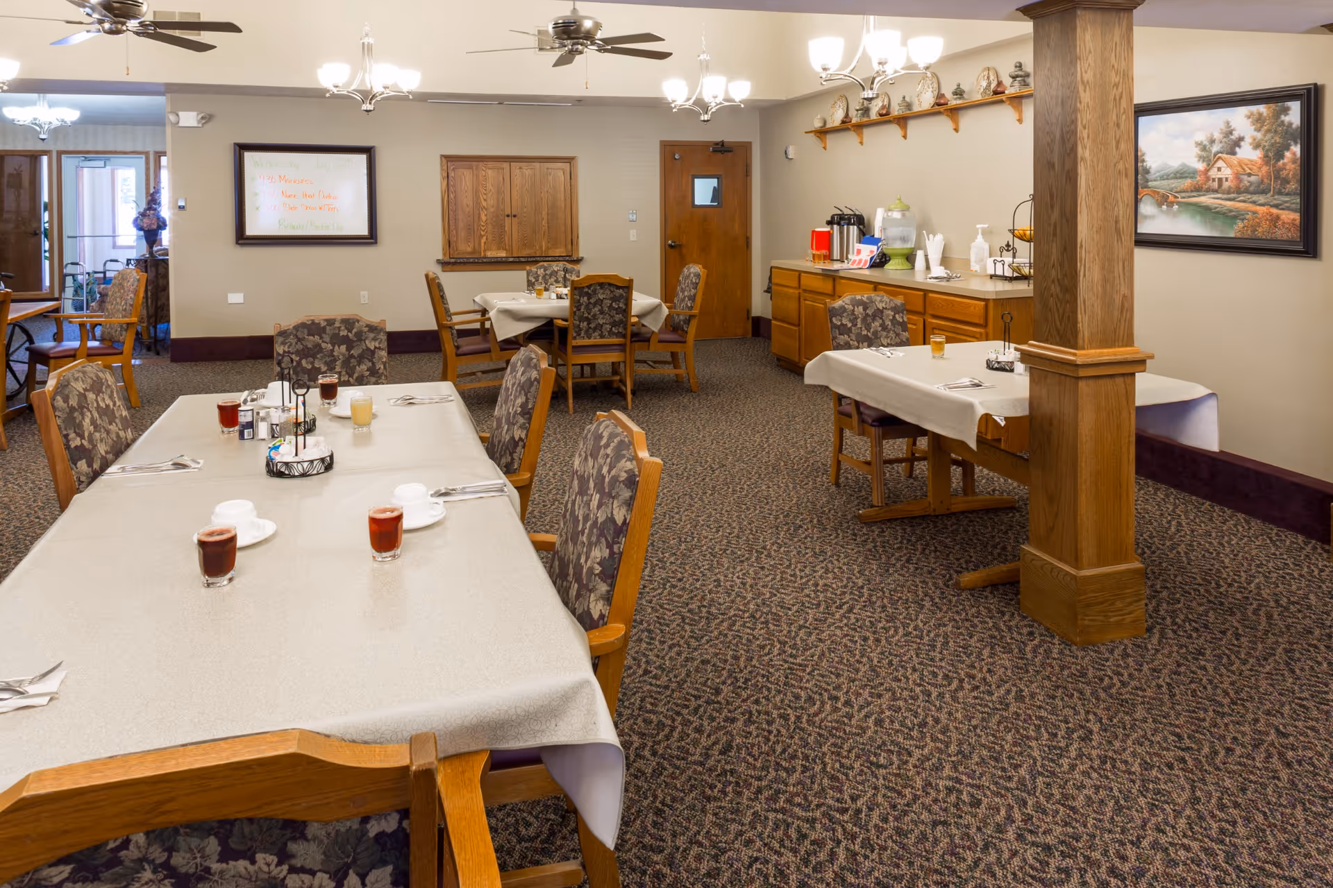 A spacious dining room with tables set for meals and a serving area.
