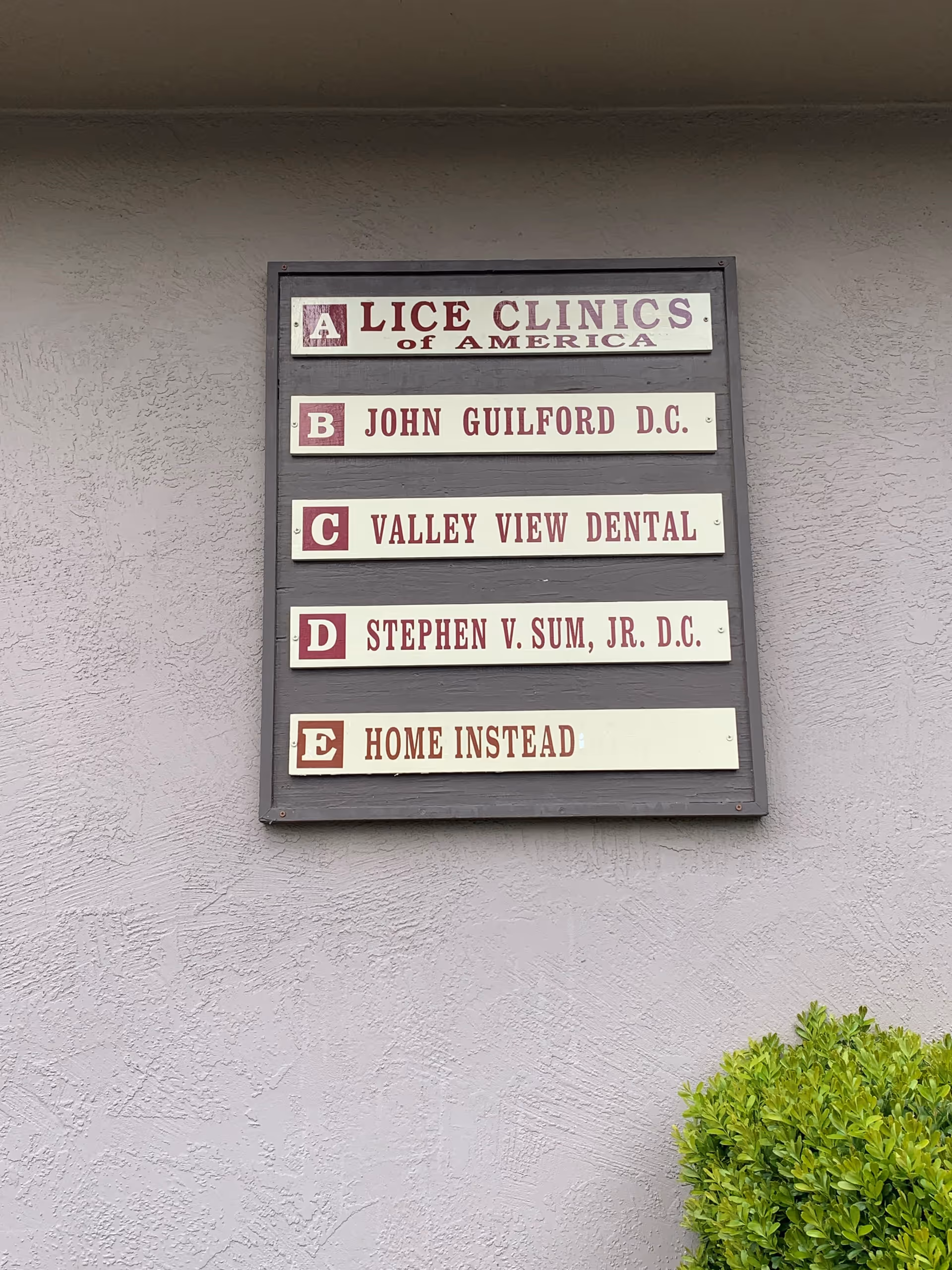 Exterior wall with a signboard listing Home Instead and other clinics.