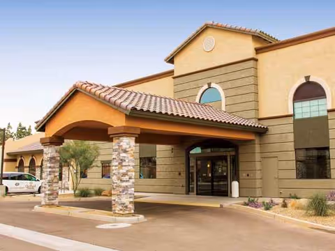 Front exterior of Orchard Pointe at Surprise, showing covered entrance and stone columns.