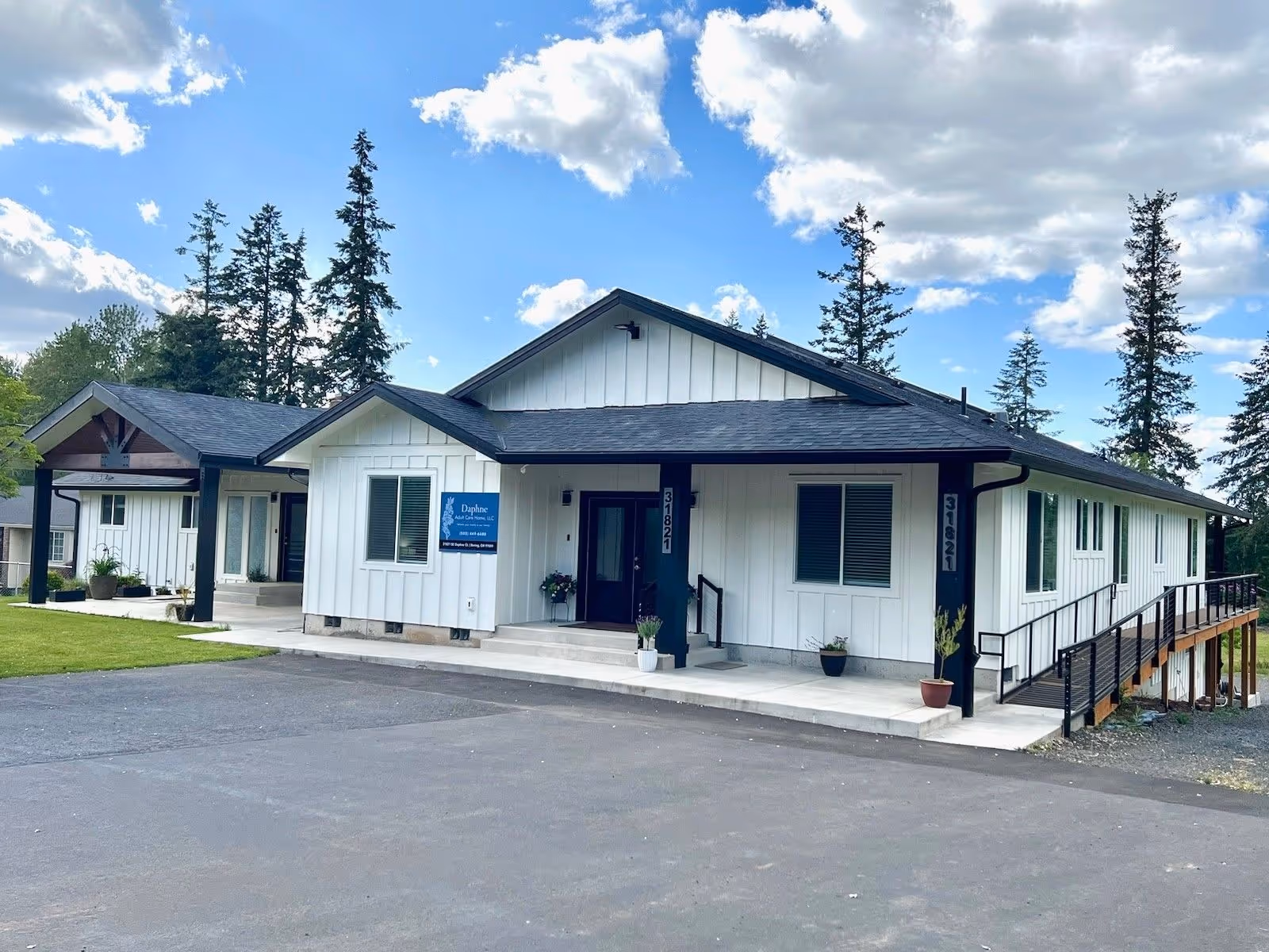 Single-story white care home with blue trim and entrance sign.