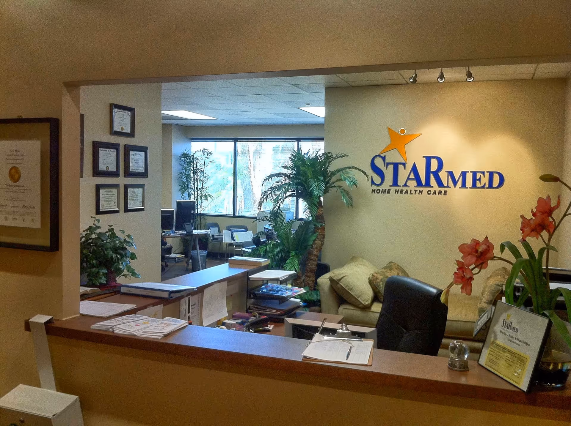 Reception desk in StarMed Home Health Care lobby with plants and seating