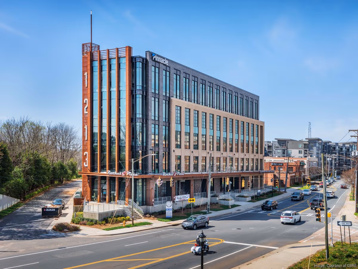 Modern mixed-use building with brick and glass facade on a city street