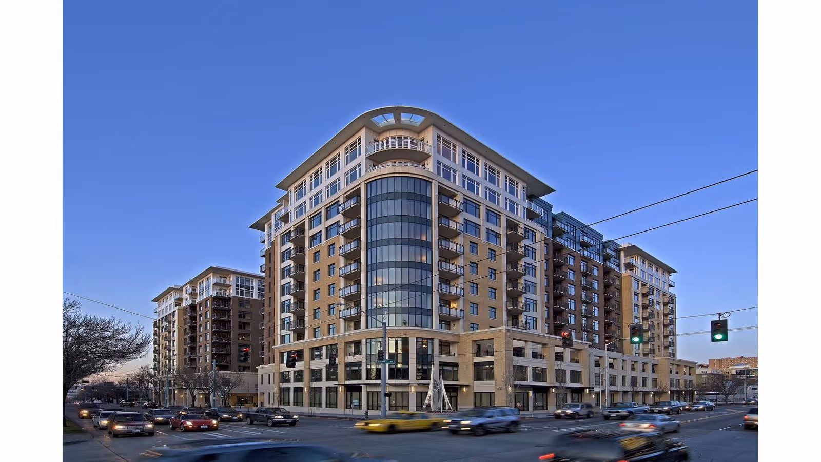 Mirabella Seattle exterior: modern multi-story building at busy street intersection.