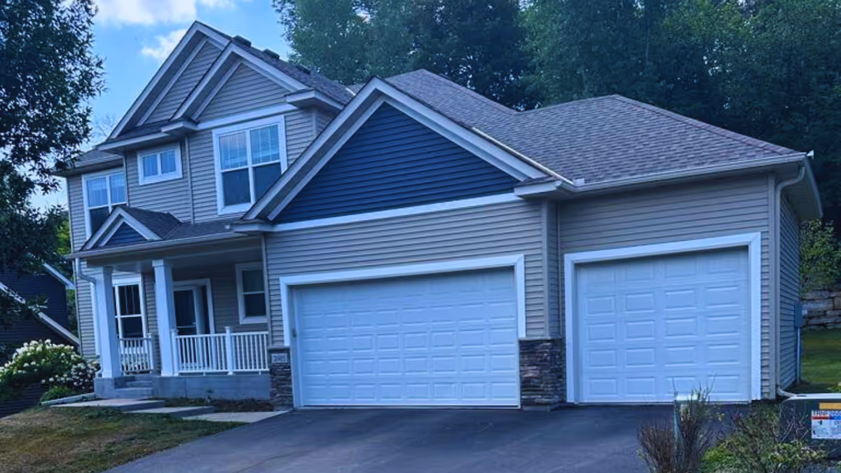 A modern suburban senior living facility exterior with a two-car garage and front porch.