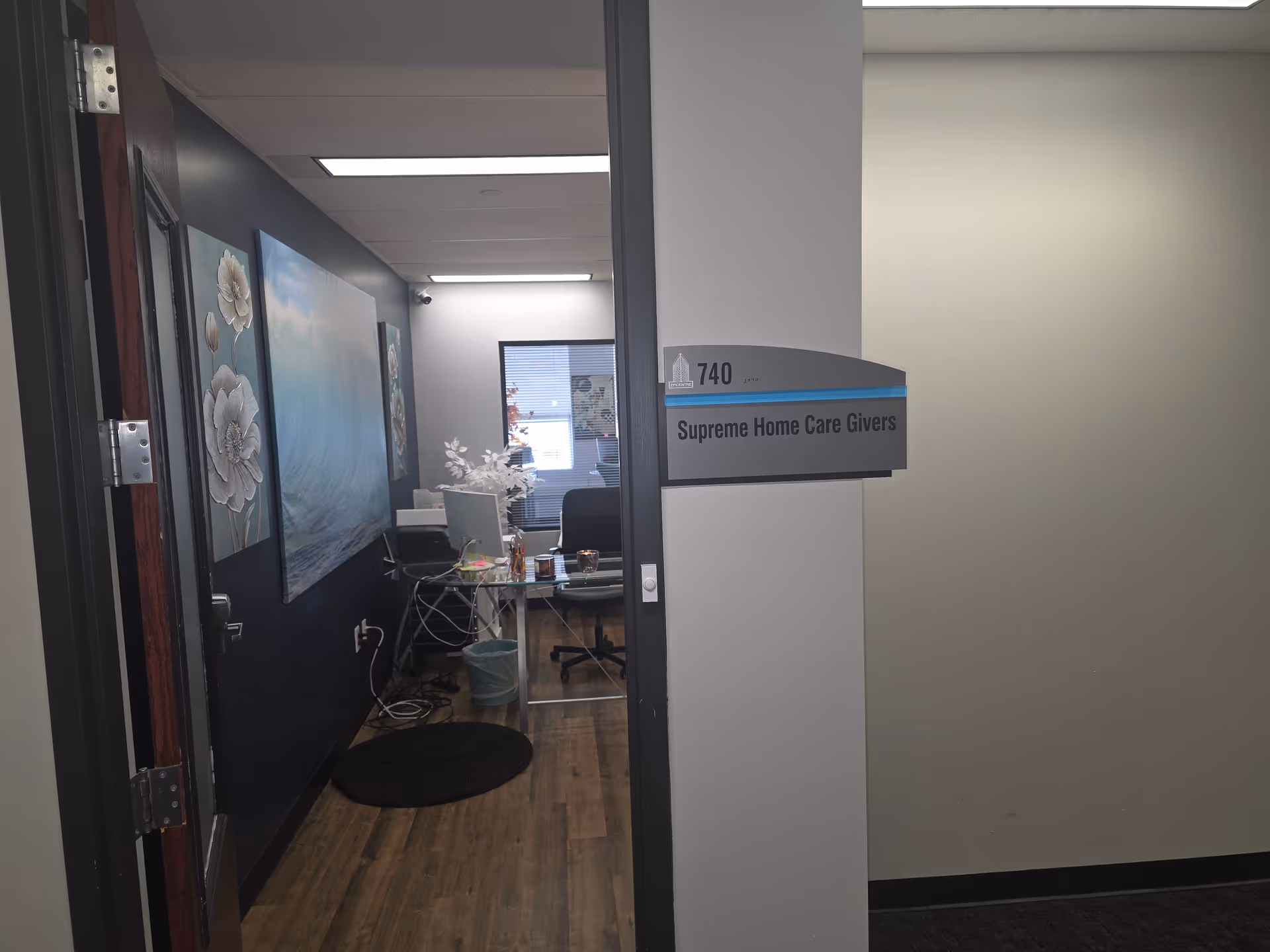 Interior office area at Supreme Home Care Givers with desk, chairs, and wall art.