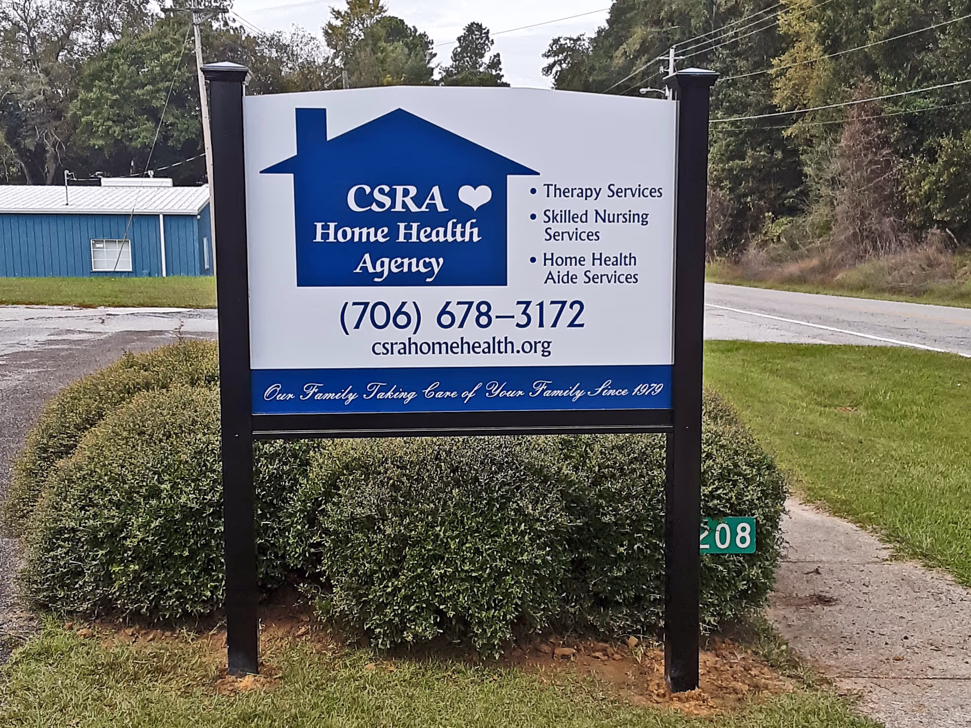 Blue and white CSRA Home Health Agency sign on a grassy front yard.