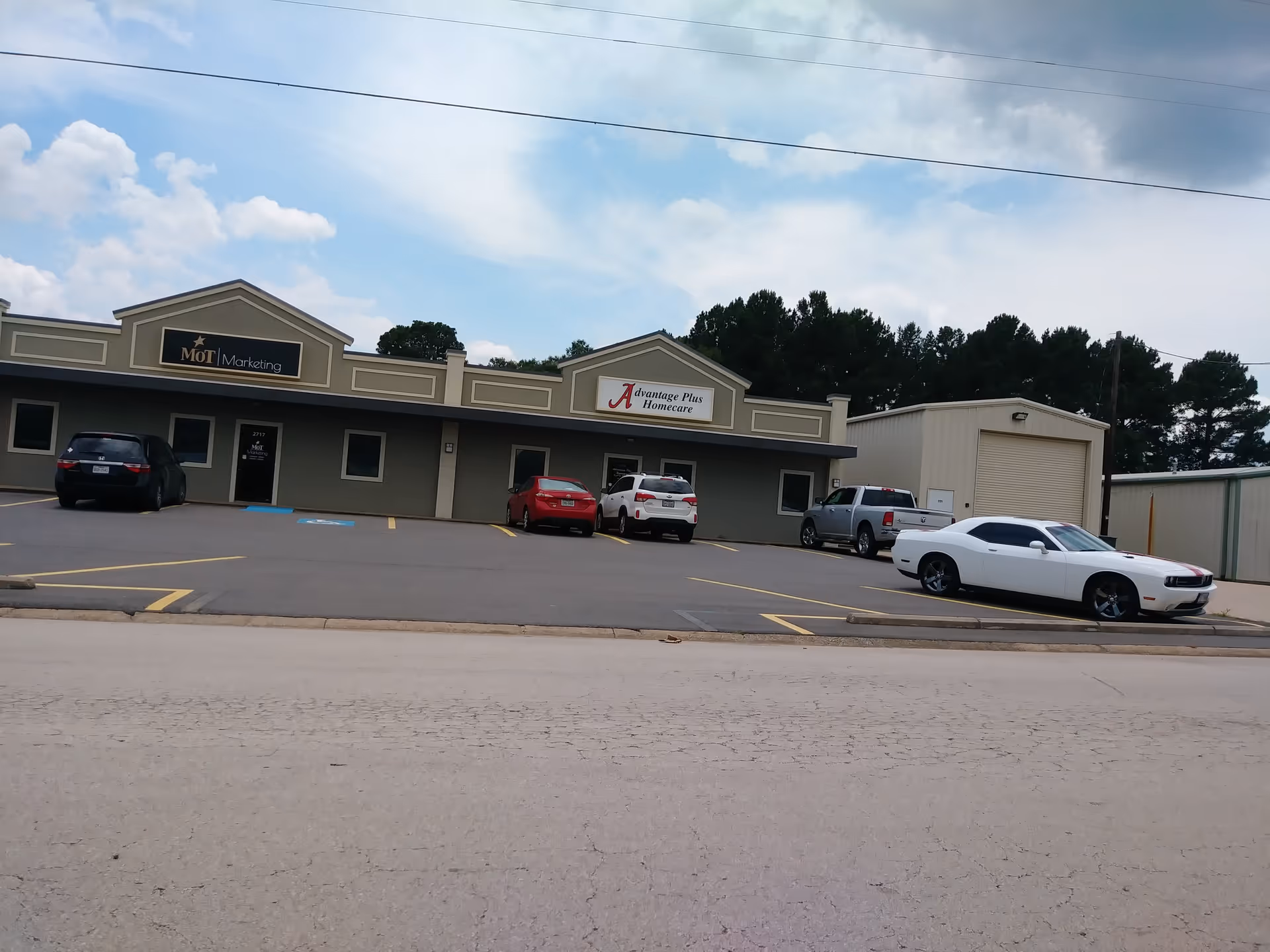 Exterior view of Advantage Plus Homecare building with several cars in parking lot.