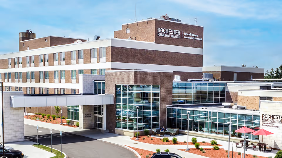 Exterior view of RRH Newark-Wayne Community Hospital with glass entrance and parking.