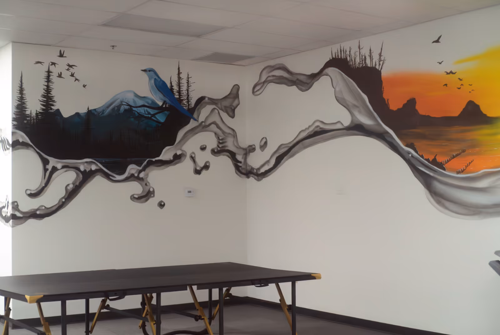 Interior room at Bluebird Health featuring a large mural and a folding table.
