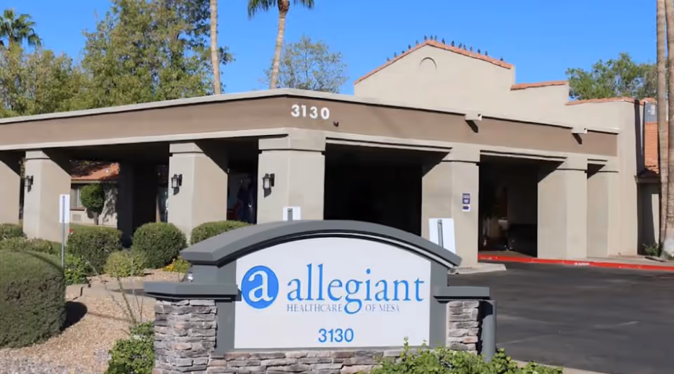 Front exterior of a beige building with an Allegiant Healthcare sign near the entrance.