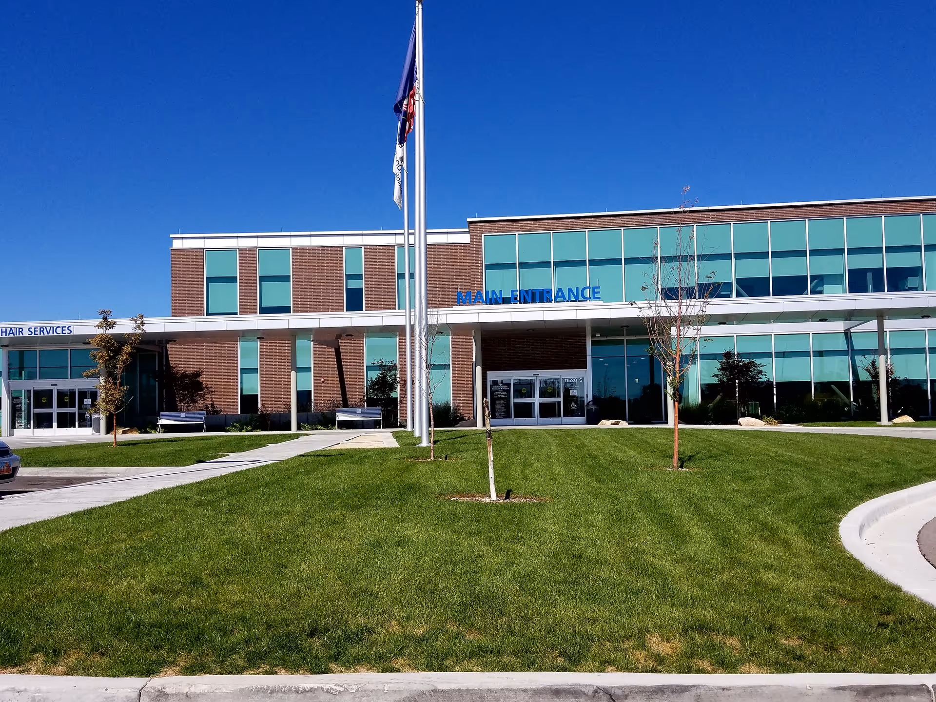 Exterior view of a modern medical facility with glass facade and main entrance.