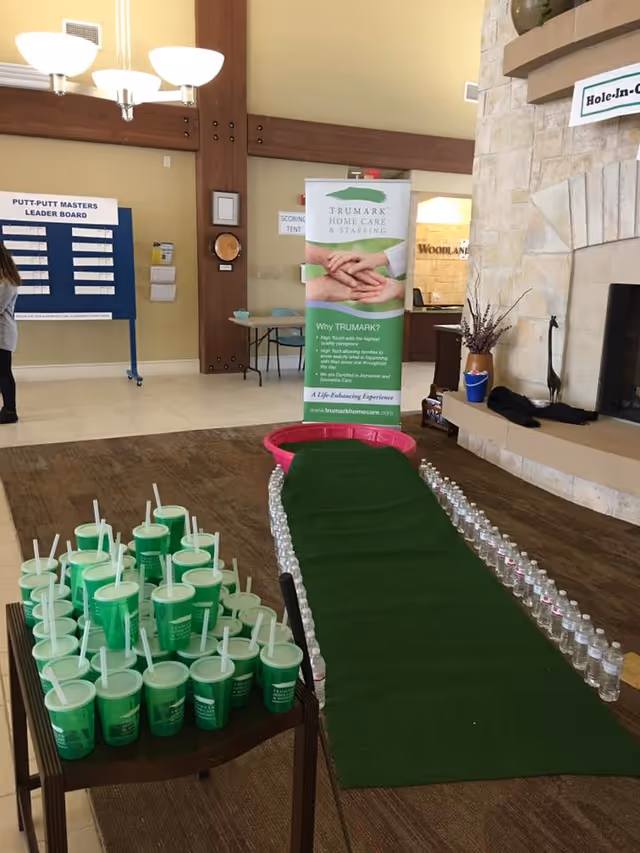 Indoor lobby with Trumark banner, Putt-Putt board, and green carpeted event setup.