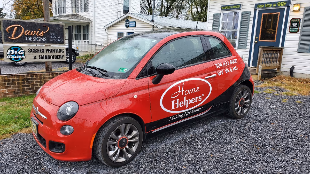Red Home Helpers car parked outside a Martinsburg storefront with signage
