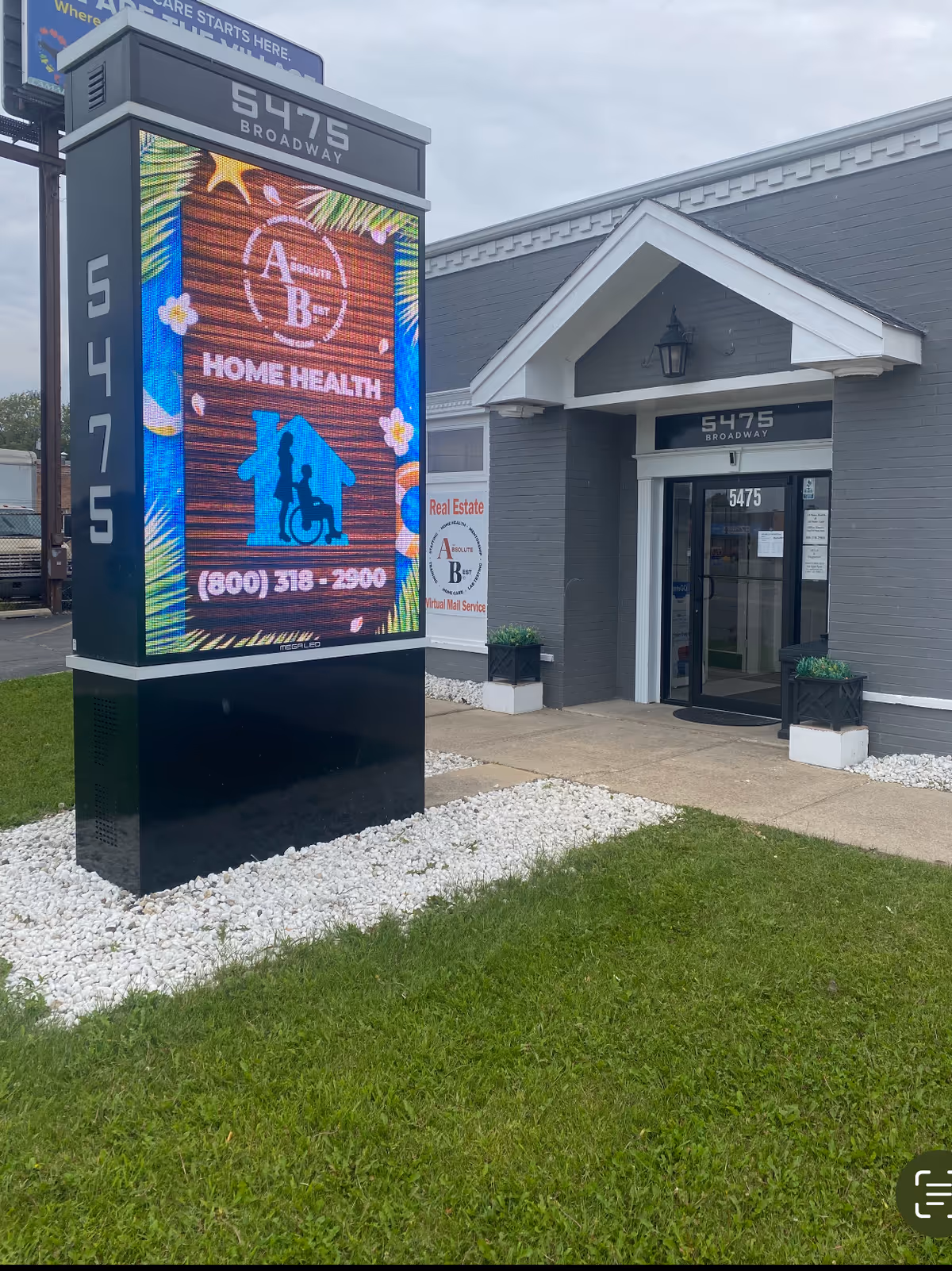 Exterior of AB Home Health building with a large digital sign and entryway.