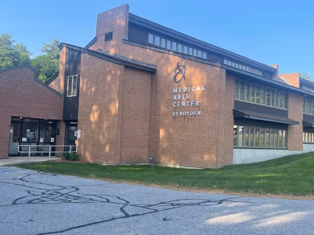 Brick building with a Medical Arts Center sign and a parking lot in front.