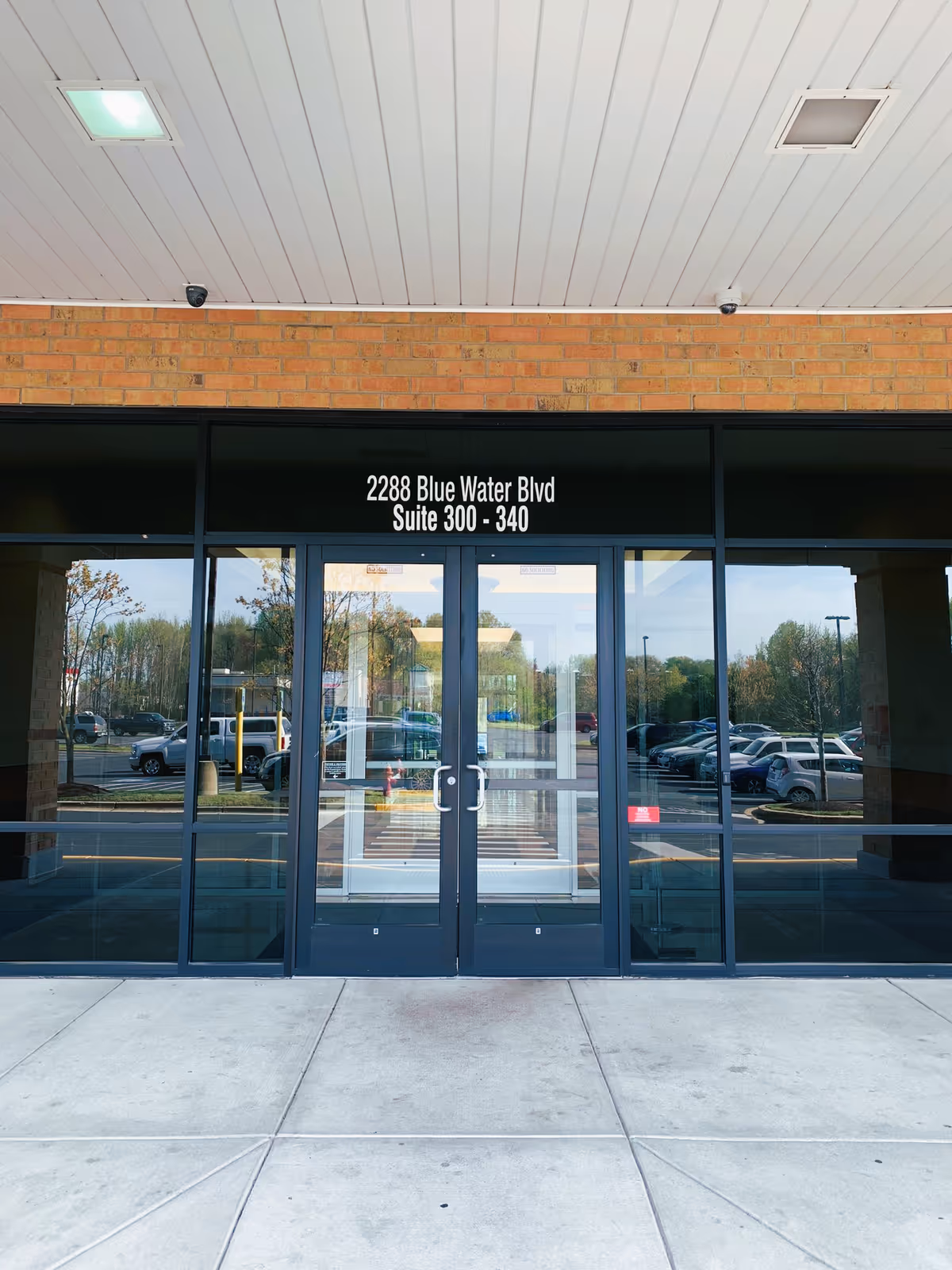 Front entrance of a brick building with glass doors and signage.