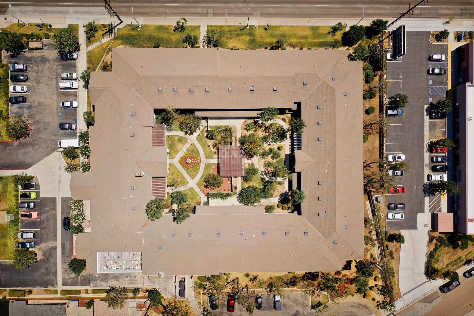 Aerial view of Discovery Commons Whittier—U-shaped senior living building with central courtyard.
