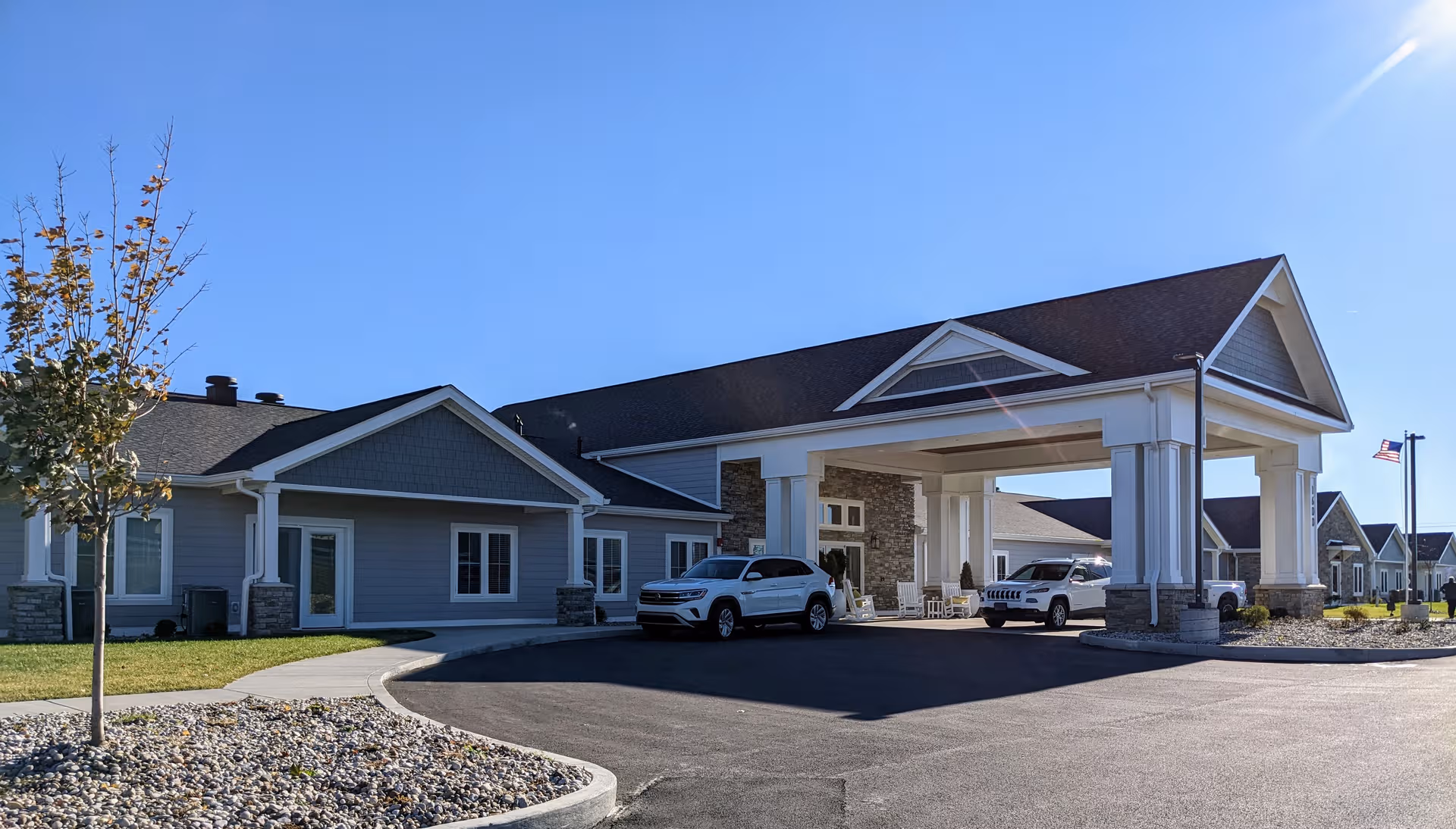 Exterior view of Cedarhurst Senior Living facility with porte-cochère and parked cars.