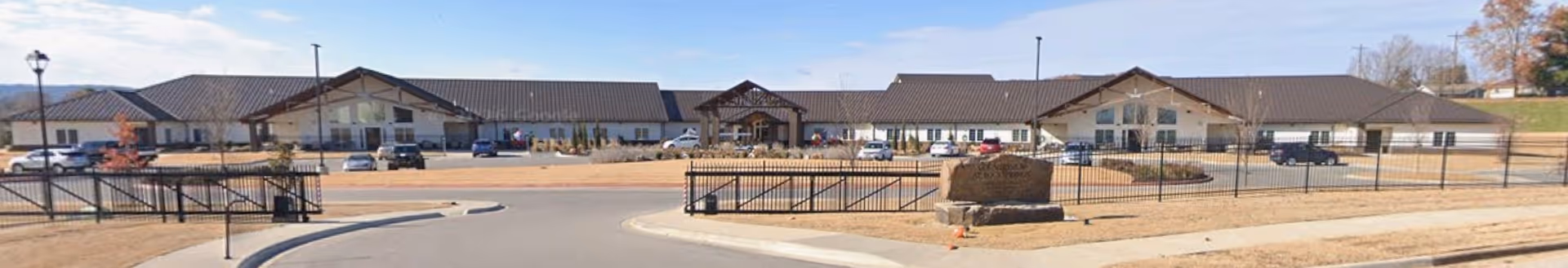 Panoramic exterior view of Countryside at Rock Springs facility with parking and gate.