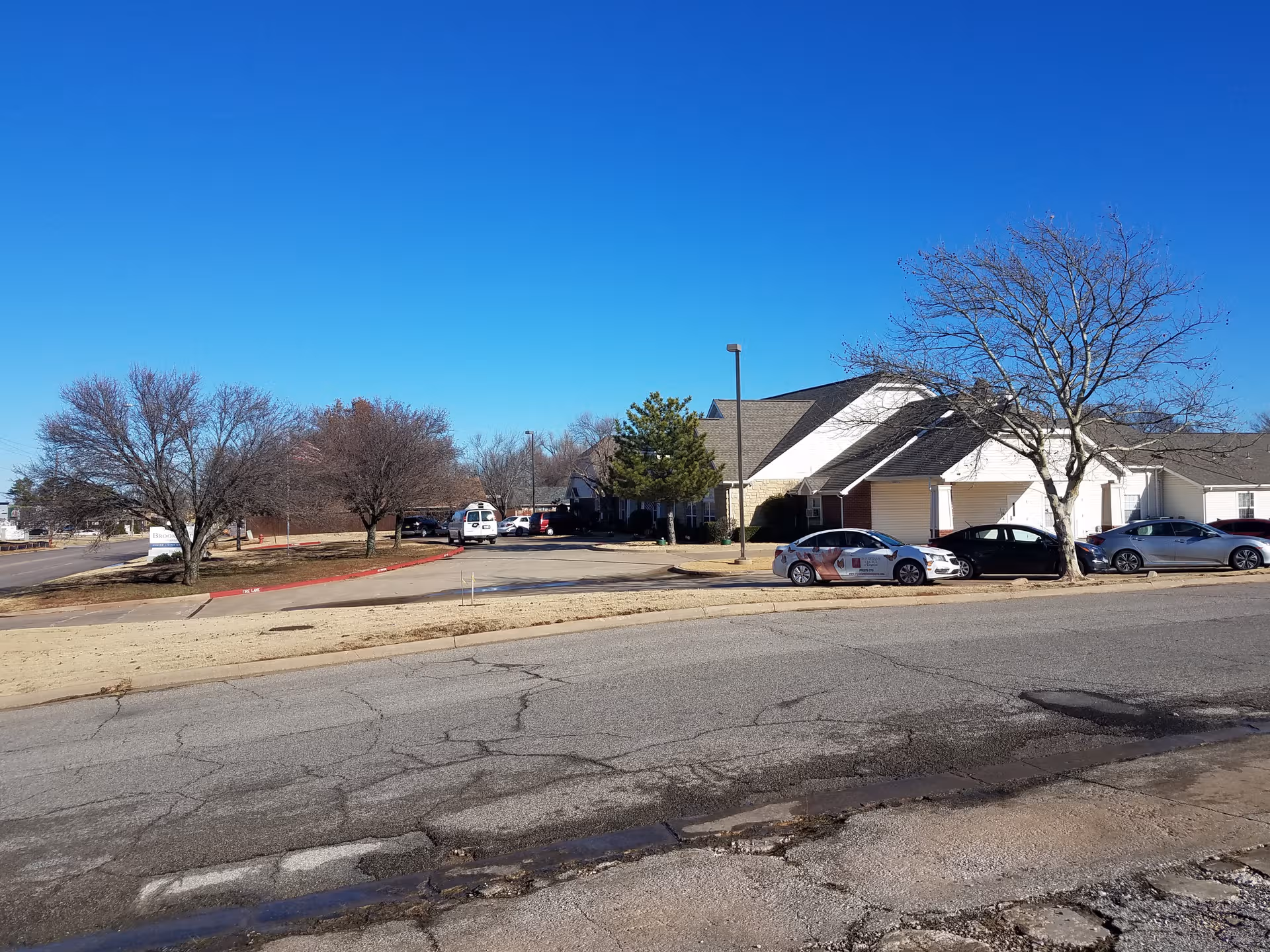 Exterior view of Brookdale Shawnee with parked cars along a street in front.