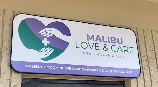 Exterior sign for Malibu Love and Care Healthcare Agency with heart and hands logo.