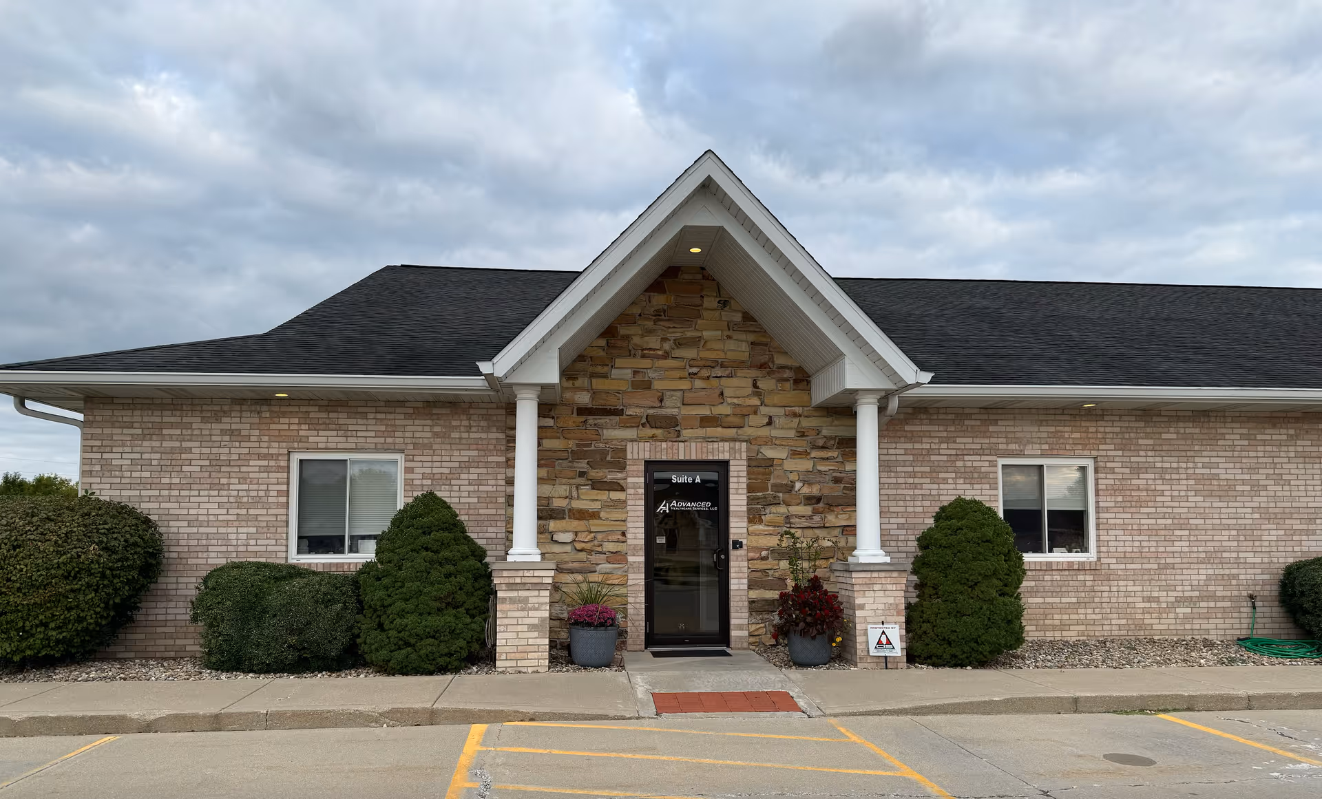 Brick building housing a senior living facility with stone facade and a covered entrance.